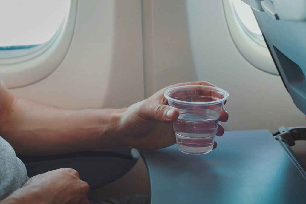 Passenger drinking water in an aircraft cabin